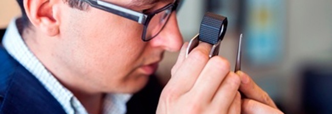 Man inspecting diamond with scope image